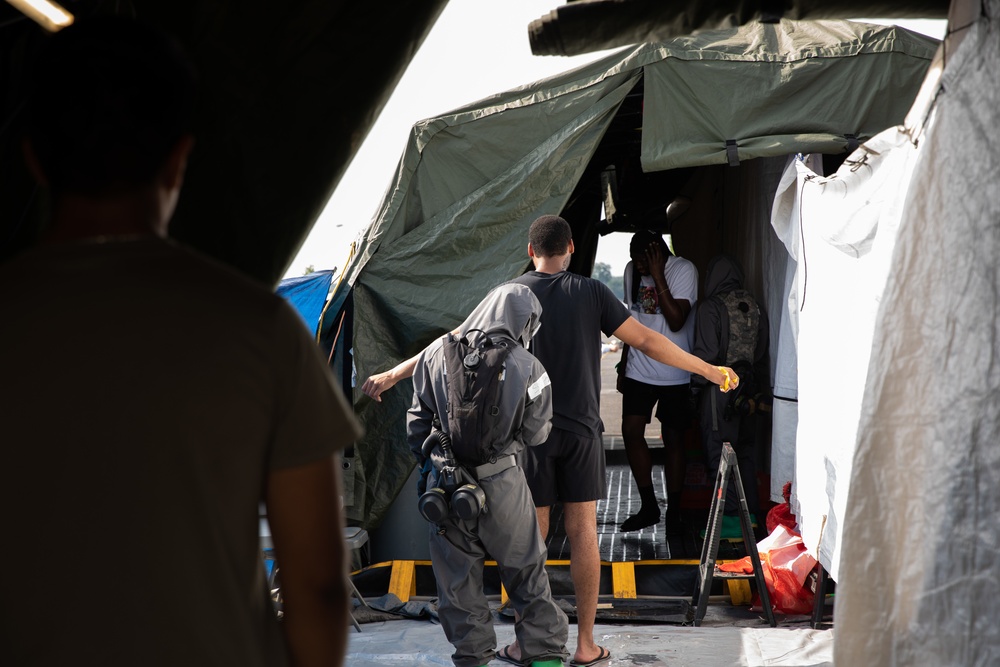 140th Chemical Company moves volunteers through a decontamination area
