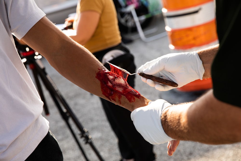 Civilian role players receive simulated injuries before seeking medical attention