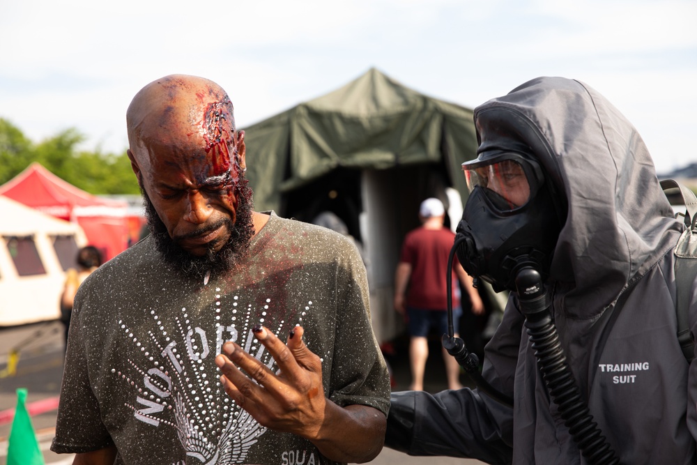 140th Chemical Company Soldier assists volunteer in the decontamination line