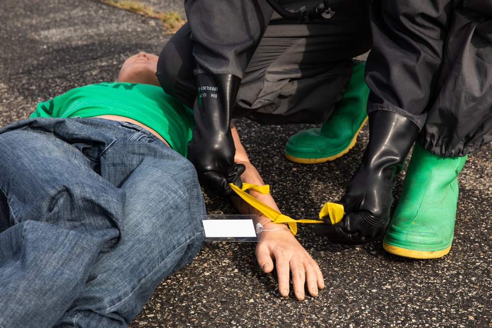 140th Chemical Company Soldier attaches injury category marker to mannequin patient