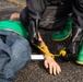 140th Chemical Company Soldier attaches injury category marker to mannequin patient