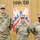 Three U.S. Army soldiers in OCP (Operational Camouflage Pattern) uniforms are posed in front of a 16th Sustainment Brigade sign and insignia. Their name tapes are visible: Sikorski (left), George (center), and Parker (right). The center soldier (George) displays a rank insignia consistent with a First Lieutenant (1LT).
