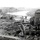 A black-and-white aerial photograph showing a devastated urban landscape with near-total destruction across a wide area. A distinctive domed building structure remains partially standing on the right side, surrounded by rubble and ruins extending to the horizon. A river is visible in the background, with a few surviving multi-story buildings visible in the far distance.