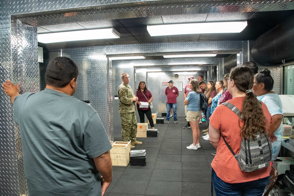 Tech. Sgt. John Brown shares information about the Modular Containerized Small Arms Training Set (MCSATS) facility (indoor shooting range) during a base tour on Aug. 1, 2022