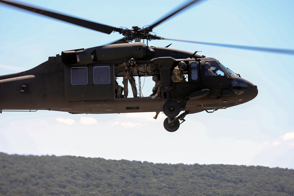 Scouts from the 1/110th Infantry Regiment rappel from a UH-60 Black Hawk during a live fire training exercise.