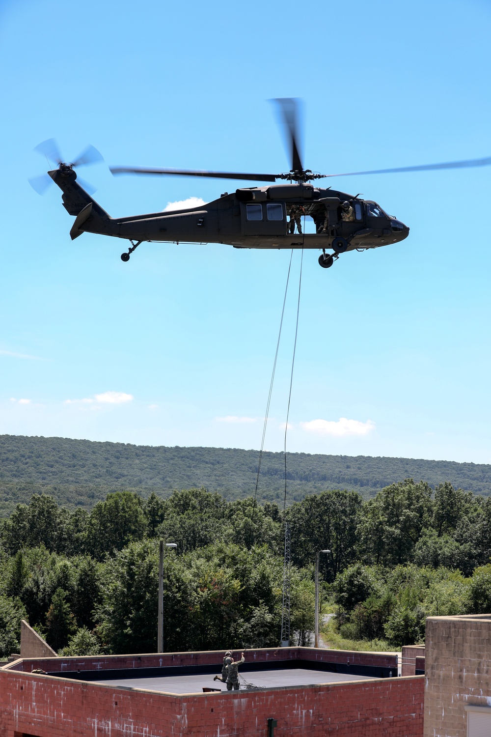 Scouts from the 1/110th Infantry Regiment rappel from a UH-60 Black Hawk during a live fire training exercise.