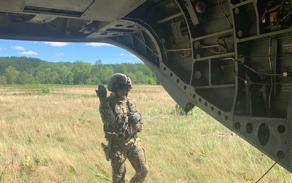 Crew Chief signals Soliders to depart CH-47 Chinook helicopter