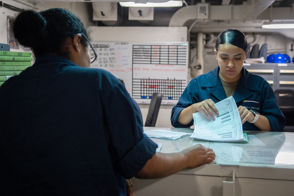 USS Ronald Reagan (CVN 76) Sailors work in Main 2 supply room