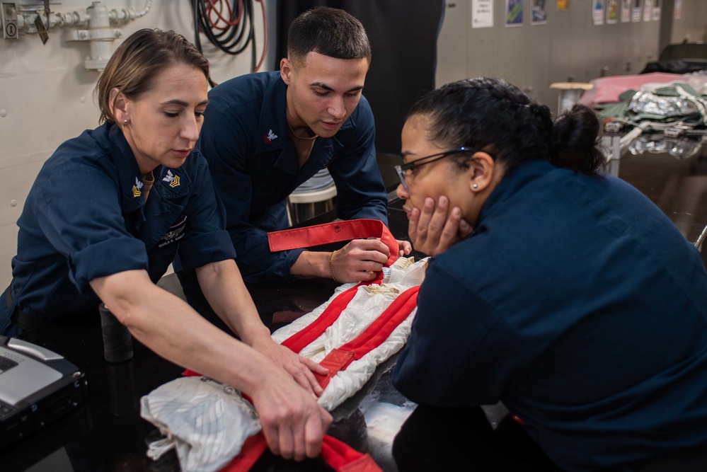 USS Ronald Reagan (CVN 76) Sailors pack and prepare parachutes