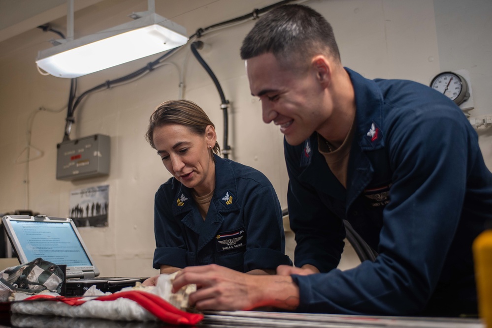 USS Ronald Reagan (CVN 76) Sailors pack and prepare parachutes