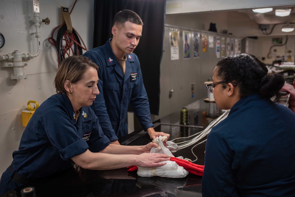 USS Ronald Reagan (CVN 76) Sailors pack and prepare parachutes