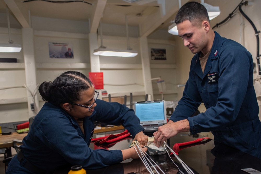 USS Ronald Reagan (CVN 76) Sailors pack and prepare parachutes