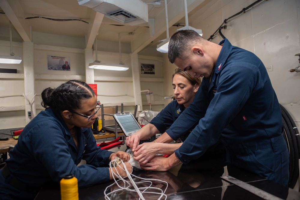 USS Ronald Reagan (CVN 76) Sailors pack and prepare parachutes