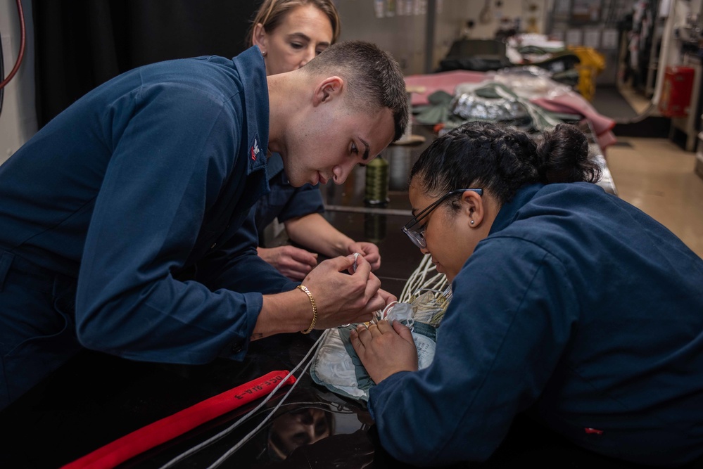 USS Ronald Reagan (CVN 76) Sailors pack and prepare parachutes