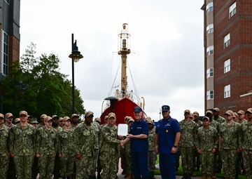 Coast Guard Vice Adm. Kevin Lunday, Atlantic Area Commander, presents the crew of the USS Hershel "Woody" Williams with the Coast Guard Special Operations Service Ribbon