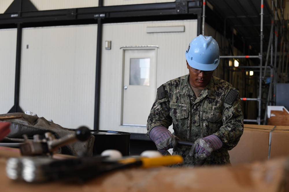 Sailor transports cargo in the hangar bay of USS Carl Vinson