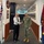 Two military officers are shaking hands in a formal corridor setting. The location appears to be the Office of the Chief of Navy, indicated by a visible plaque on the wall. One officer wears an Australian Navy white dress uniform while the other wears a US Navy NWU Type III (woodland camouflage) uniform.