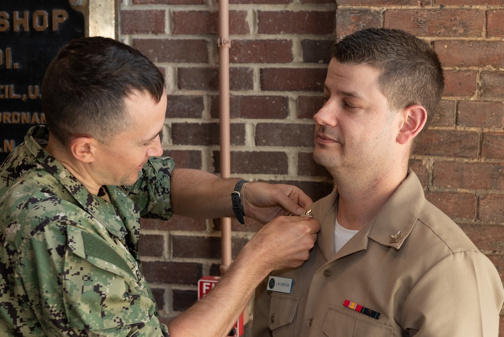 Musician 1st Class Jeff Harrigan is pinned upon arrival at U.S. Navy Band