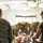 Military personnel in MARPAT camouflage uniforms are conducting a medical training exercise inside a field tent. They are working on a medical training mannequin/simulator placed on a litter/stretcher, practicing combat casualty care procedures. The setting appears to be a forward surgical or aid station training environment.