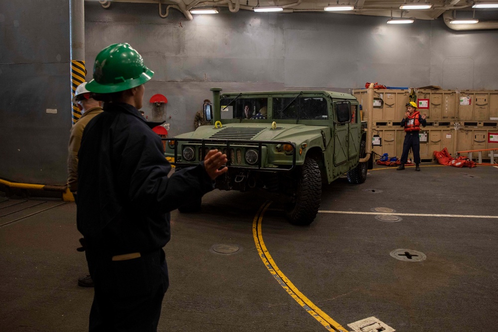 U.S. Navy Boatswain’s Mates direct a High Mobility Multipurpose Wheeled Vehicle