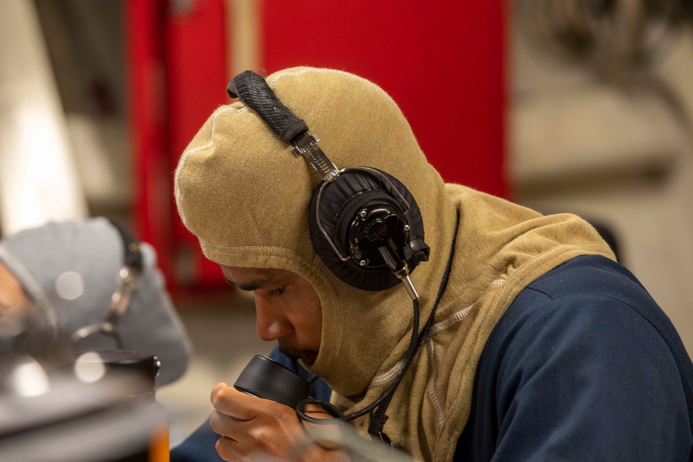 U.S. Navy Sailors Speaks into a Sound-Powered Telephone