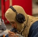 U.S. Navy Sailors Speaks into a Sound-Powered Telephone