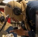 U.S. Navy Sailor Speaks into a Sound-Powered Telephone