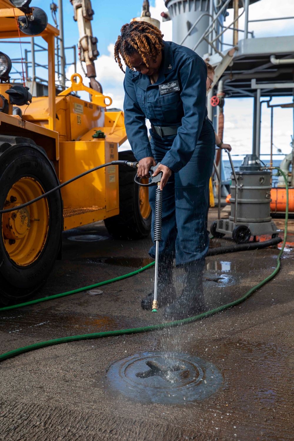 U.S. Navy Boatswain’s Mate Power-Washes the Deck