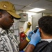 Seaman Martin Blake gives Petty Officer Third Class Kevin Strader a haircut during the full management review on aboard the USS Germantown.