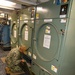 Petty Officer Third Class Joseph Rafael examines at the dryer vent to ensure it is functioning properly during the full management review on aboard the USS Germantown on Aug 31. 2022.