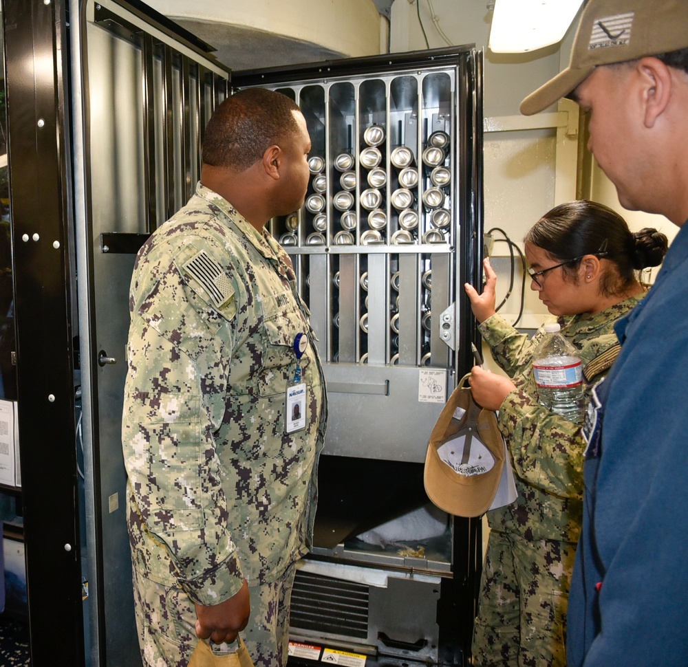 Petty Officer Third Class Leslie Benavides inspect the ships vending machine during the full management review on aboard the USS Germantown on Aug 31. 2022.