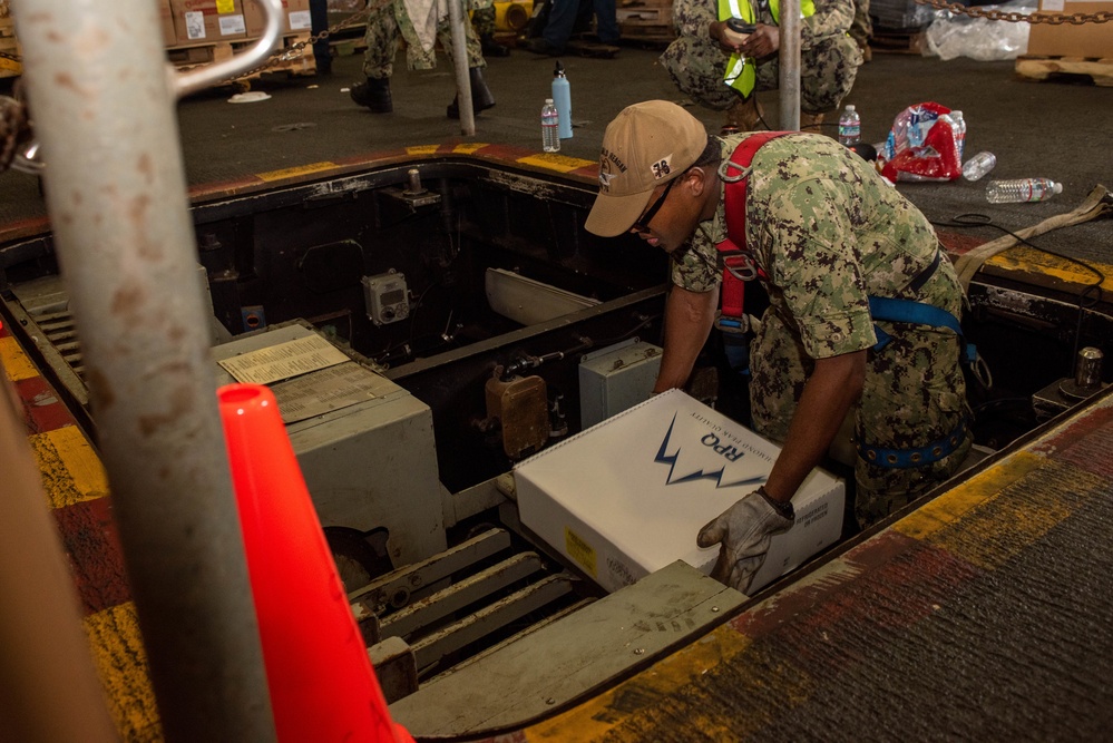 USS Ronald Reagan (CVN 76) Sailors on load cargo in hangar bay