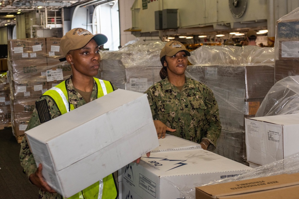 USS Ronald Reagan (CVN 76) Sailors on load cargo in hangar bay