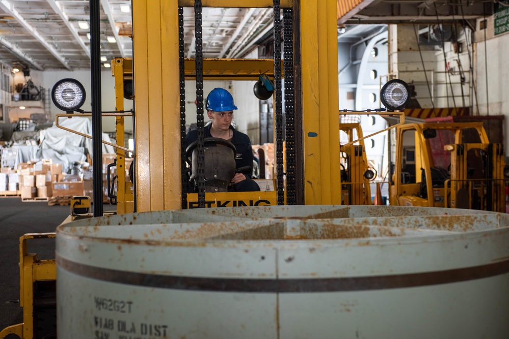 USS Ronald Reagan (CVN 76) Sailors on load cargo in hangar bay