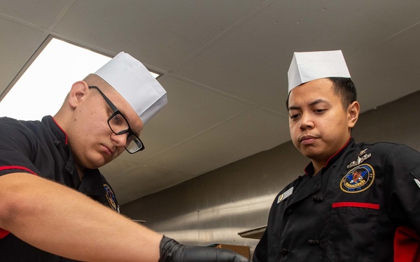 Sailors prepare food aboard APL Class Non-self-propelled Barracks Ship (APL 65)