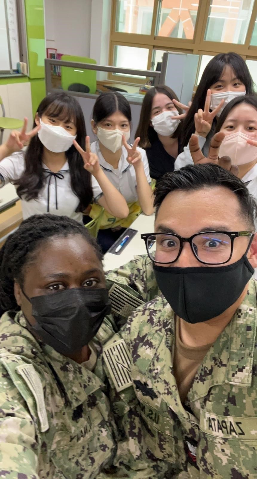 Naval Mobile Construction Battalion (NMCB) 4, pose for a selfie with local Chinhae all girls school and community center.