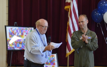 Principal Norman Burgess presents Col. Joseph Janik the student's artwork