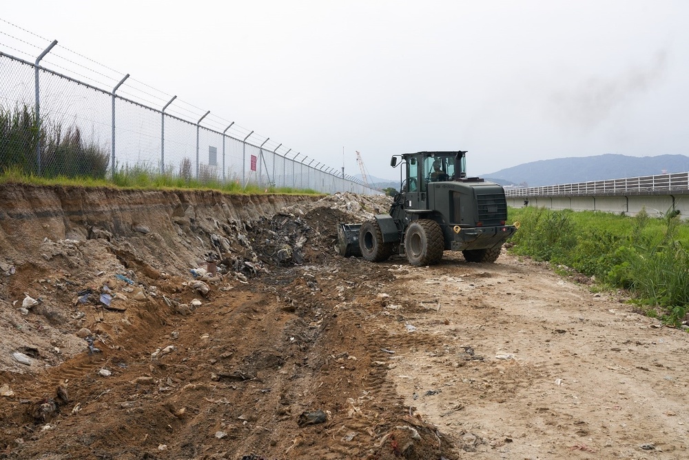 Naval Mobile Construction Battalion 4 clear away waste for future road expansion.