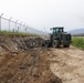 Naval Mobile Construction Battalion 4 clear away waste for future road expansion.