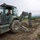 Naval Mobile Construction Battalion 4 remove overgrown vegetation and debris.