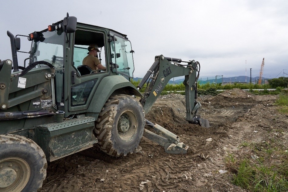 Naval Mobile Construction Battalion 4 remove overgrown vegetation and debris.