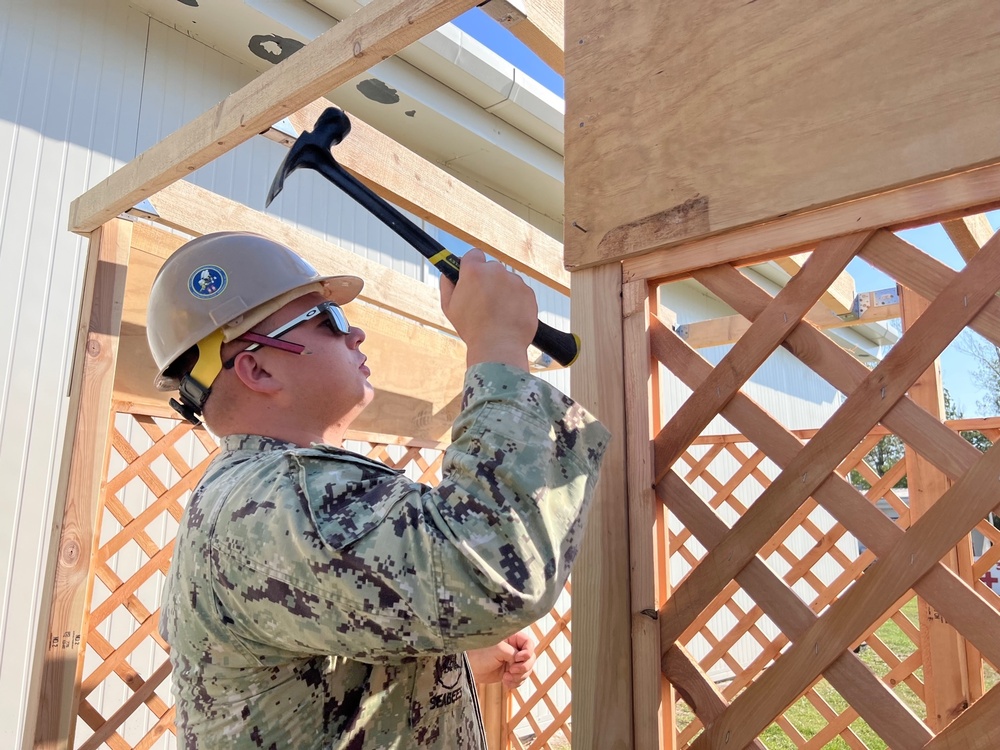 Seabee securing plywood sheathing to a Sukkah structure