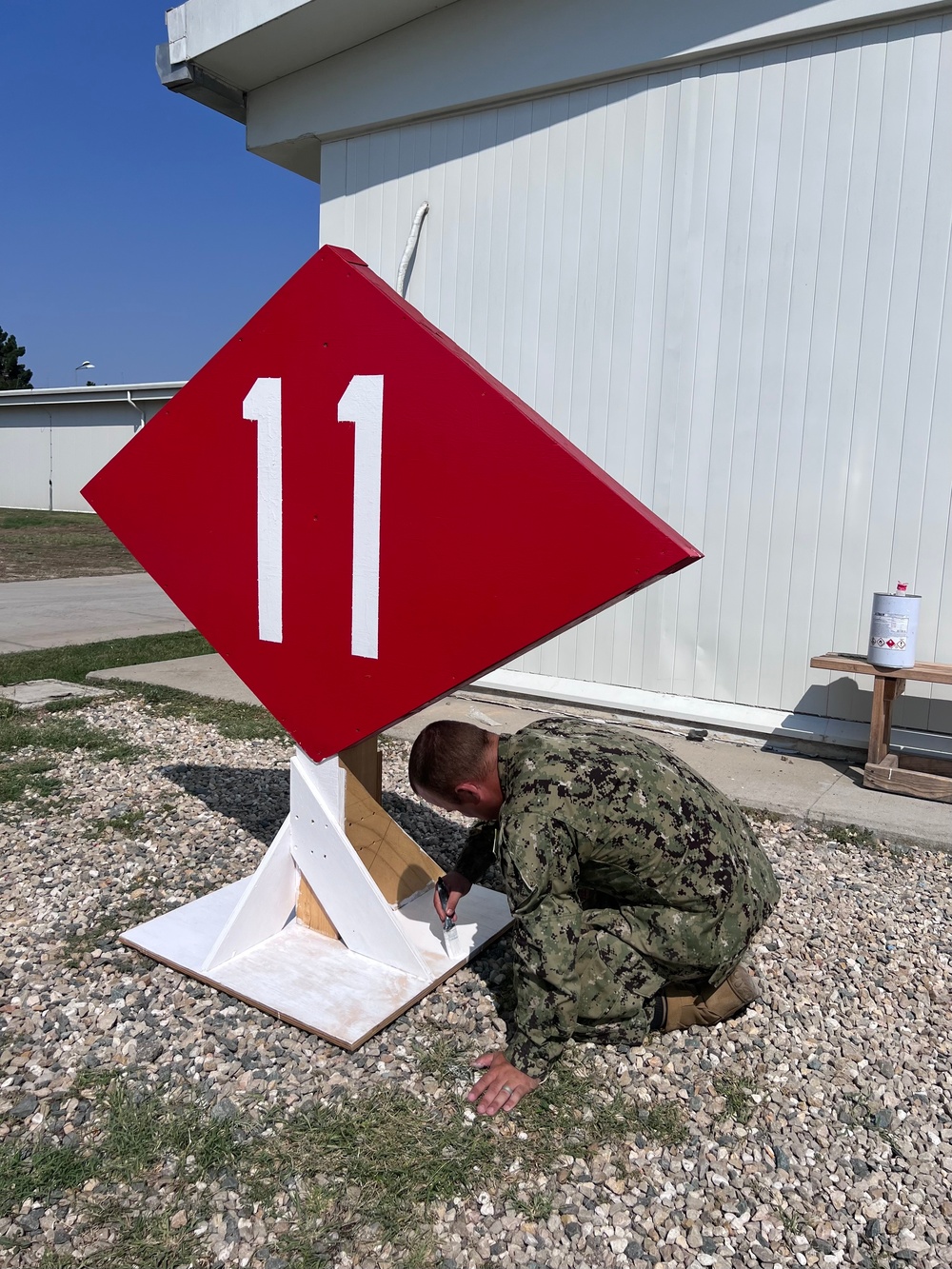 Seabees paint sign for NMCB-11 in Romania