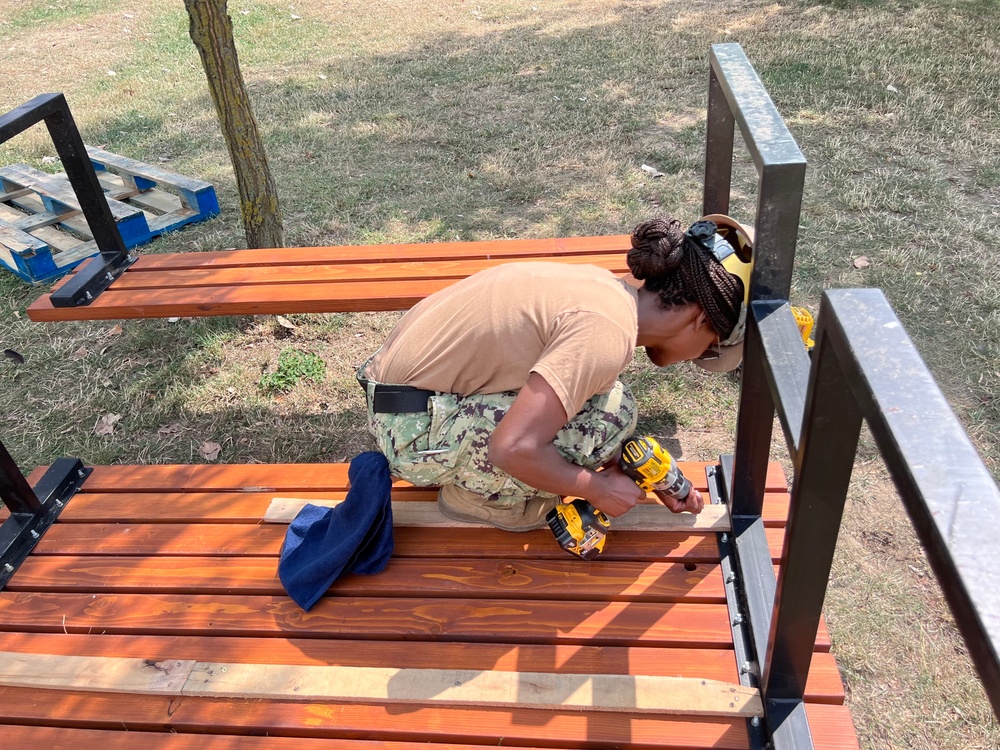 Seabees repairing a bench to prevent wobbling