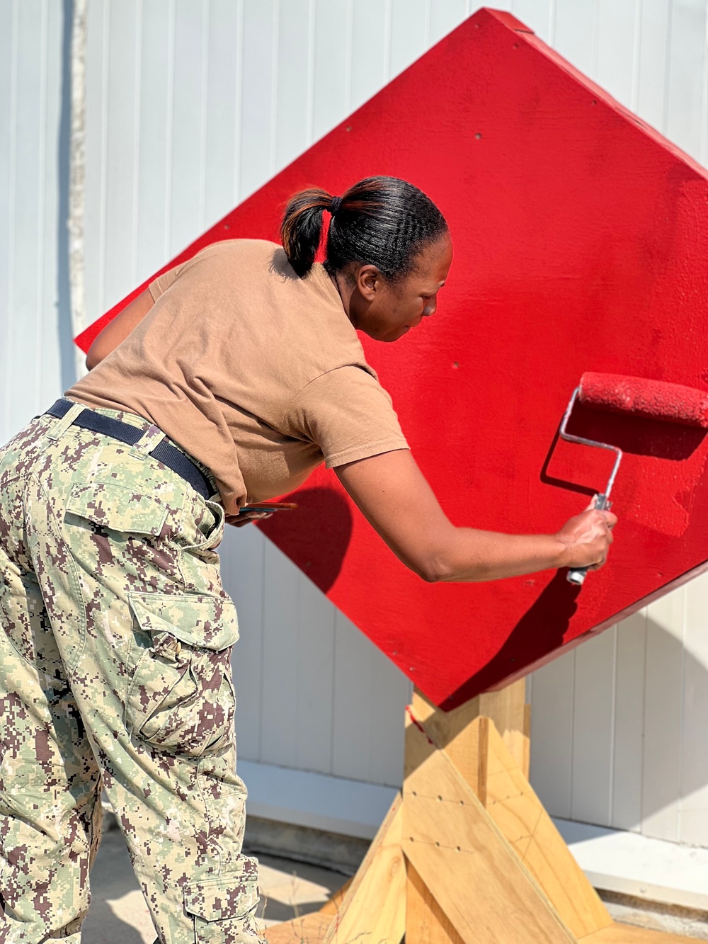 Seabees paint sign for NMCB-11 in Romania