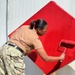 Seabees paint sign for NMCB-11 in Romania