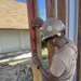 Builder 3rd Class Darren Levine, ensures a wall stud is level on the Richardson Multipurpose Facility .