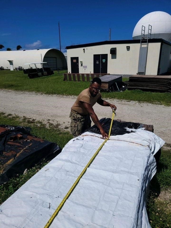 Equipment Operator 3rd Class Bobby Smith, measures and inventories materials for the Richardson Multipurpose Facility project.