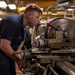 Machinery Repairman Shaves Brass Pipe