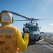 U.S. Sailor Directs An MH-60R Sea Hawk Helicopter